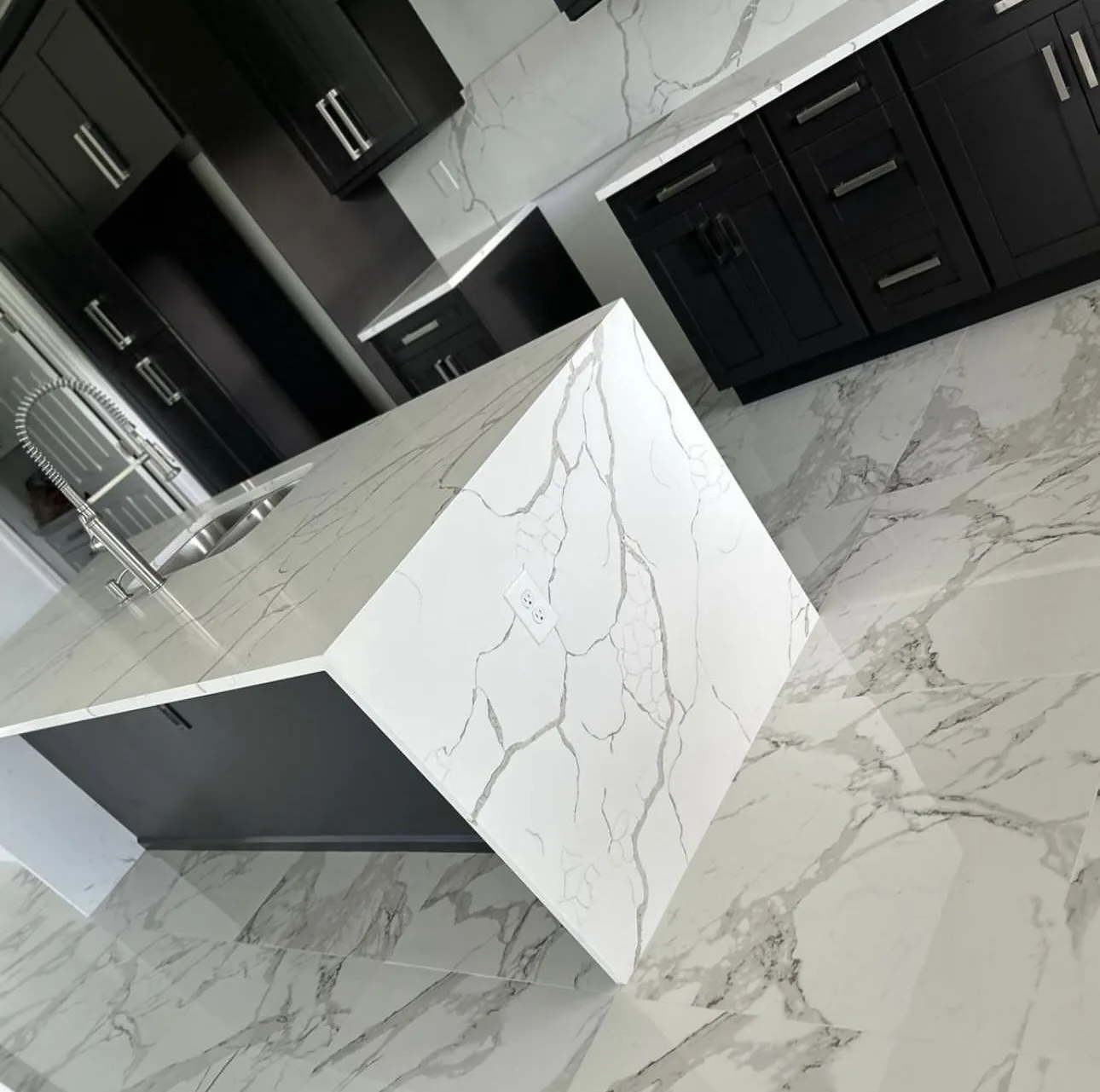 Black cabinet kitchen with dramatic waterfall quartz island